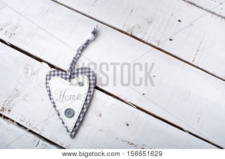 Heart with text home on the wooden background.