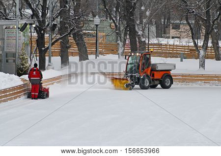 Moscow Russia - January 03 2013: Special machine and worker clean the ice skating rink in Park Gorkogo in Moscow