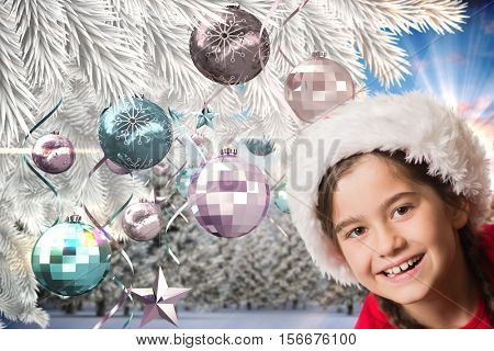 Portrait of happy girl in santa hat against digitally generated background during christmas time
