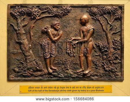 KOLKATA,INDIA - FEBRUARY 09: Gift of the half of the Devadusya (divine cloth given by Indra) to a poor Brahmin, Street bas relief on the wall of Jain Temple in Kolkata, India on February 09,2016.