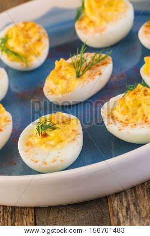 Deviled eggs garnished with fresh dill on the plate.