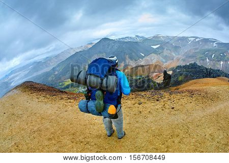hiker on the trail in the Islandic mountains. Trek in National Park Landmannalaugar, Iceland