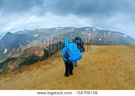 female hiker on the trail in the Islandic mountains. Trek in National Park Landmannalaugar, Iceland