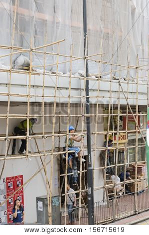 Hong Kong - October 17, 2016: Construction workers build a wooden framework in downtown Hong Kong