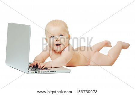Happy little baby lying in front of a silver laptop and presses a button.