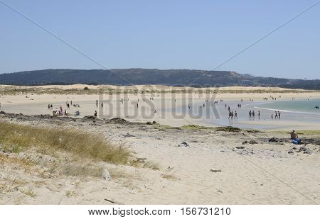 CORRUBEDA, SPAIN - AUGUST 10, 2016: People in a beach of natural dunes in Corrubedo Galicia Spain