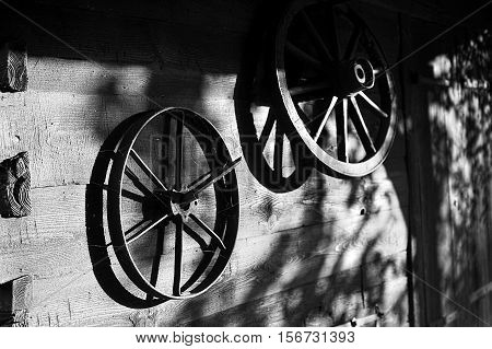 Vintage wheels various carts on the background of a wooden wall. Film noir style image.