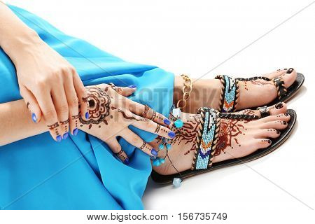 Female legs and hands with henna tattoo on white background