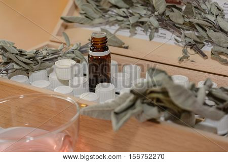 Brown glass bottle and other bottles in a wooden box behind it sage