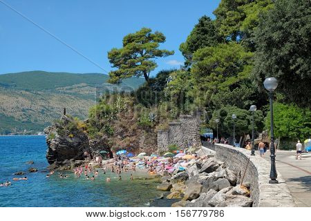 HERCEG NOVI, MONTENEGRO - JULY 18, 2016: small beach crowded of sunbathers along Herceg Novi promenade