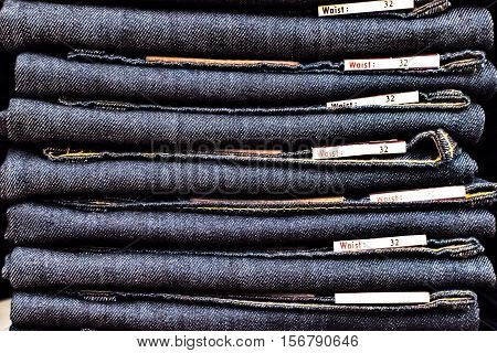Many jeans waist thirty two on shelf in the store.