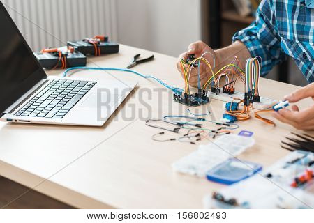 Workplace of engineer experimenting with electronics, free space. Programmer checking his new invention. Modern technologies, electronics, diy product engineering