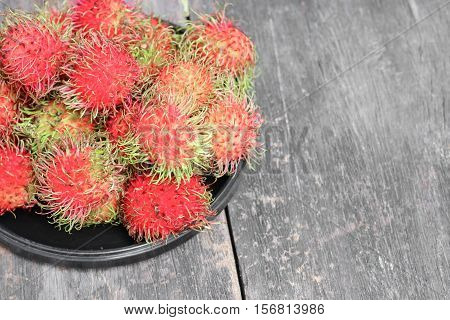 rambutan sweet fruit fresh in plate on wood background :Select focus with shallow depth of field.