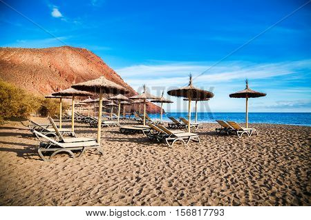 Chaise-longues And Sun Umbrellas In Playa De La Tejita