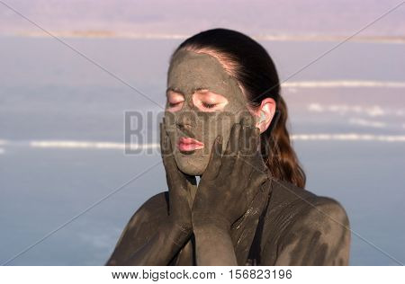 Woman Puts Mineral Beauty Mud On Her Body In The Dead Sea, Israel