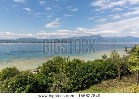 Landscape of the coast of Sirmione peninsula which divides the lower part of Lake Garda. It is a famous vacation place for a long time in northern Italy.