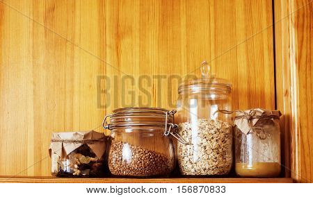 real comfort wooden kitchen with breakfast ingredients close up in glass, honey, oatmeal, milk, muesli, morning food