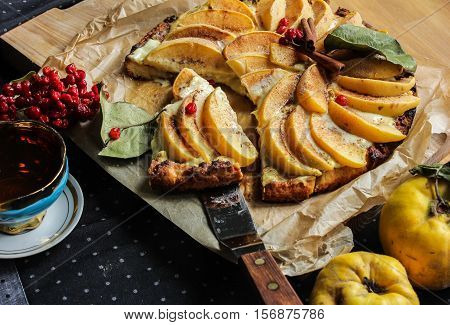 Homemade flour cake with quince and cooking utensils