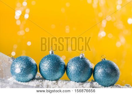 Four turquoise Christmas baubles on snow. Xmas greeting card.