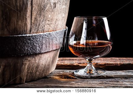 Brendy Glass And Old Oak Barrel On Black Background