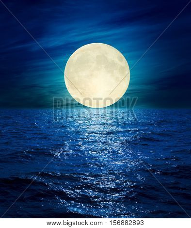 big moon in clouds over night sea