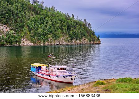 LAKE BAIKAL IRKUTSK REGION RUSSIA - July 28.2016: Baikal landscape with a walking yacht on shore of small bay. Vehicles for transport of leisure travelers and walks on water of Lake Baikal.