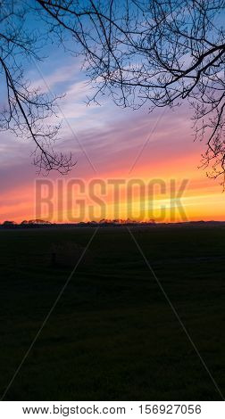 Colorful sunset and intens sky over traditional agricultural landscape in spring