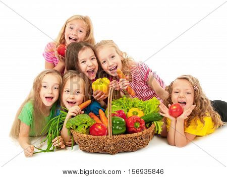 Happy little girls with basket of vegetables