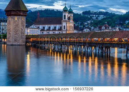 Night view towards Chapel Bridge (Kapellbruecke) together with the octagonal tall tower (Wasserturm) it is one of the Lucerne's most famous tourists attraction