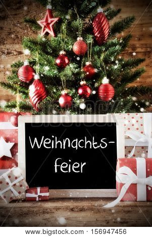 Chalkboard With German Text Weihnachtsfeier Means Christmas Party. Christmas Tree With Balls And Snowflakes. Gifts Or Presents In The Front Of Wooden Background With Bokeh Effect