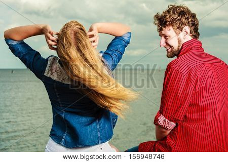 Couple Relaxing On Sea Shore Rear View