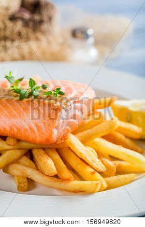Hot French Fries With Salmon Served On Plate With Lemon