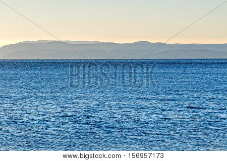 Blue sea landscape in front of the Tucepi town beach, view of island Brac coast.