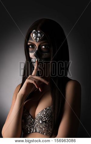 Santa Muerte concept. Beautiful model doing silence gesture