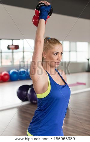 Fitness Woman Using Kettlebells Inside Gym