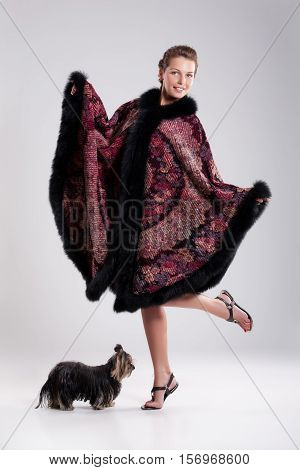 Young beautiful brunette in an embroidered handmade tippet on an isolated background