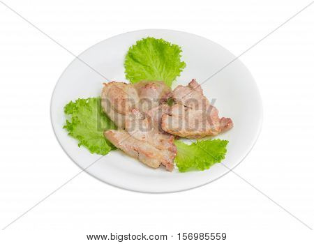 Three slices of fried pork neck on lettuce leaves on white dish on a light background
