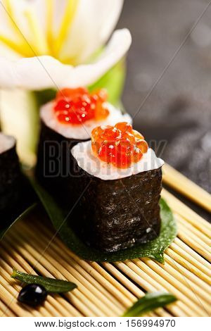 Ikura Maki Sushi - Roll with Cream Cheese inside. Topped with Ikura (Salmon Roe). Sushi Food and Natural Flower Concept