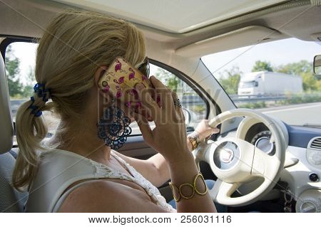 Bottrop, Germany - Aug 16, 2018: A Blond Woman Is Calling With Her Smartphone While She Is Driving O