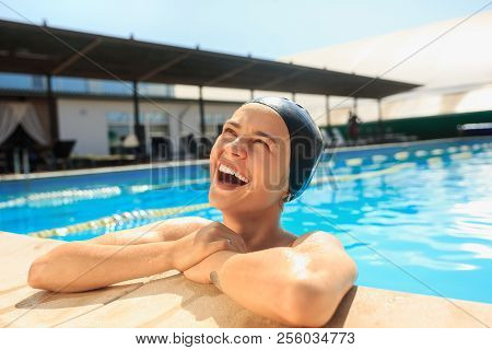 The Portrait Of Happy Smiling Beautiful Woman At The Swimming Pool. Female Caucasian Model At Blue W