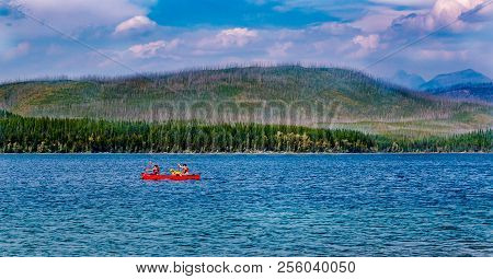 Tourist Paddling Their Canoe On A Mountain Lake