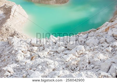 Kaolin white clay quarry open pit at summer day with blue water