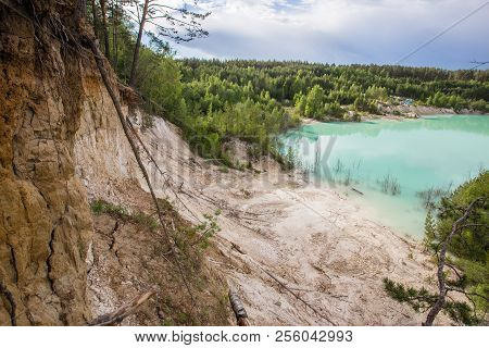 Kaolin white clay quarry open pit at summer day with blue water
