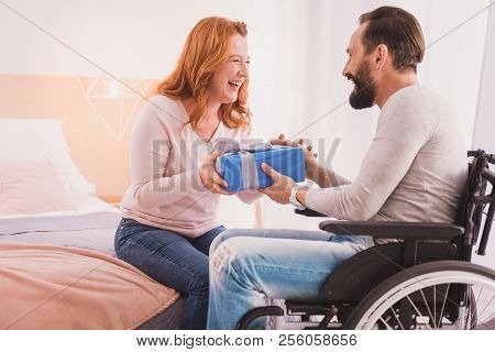 Joyful Woman Making A Present For Her Husband