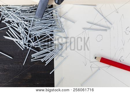 Drawing Of A Birdhouse With Boards, Pencil, Zinc Plated Nails With A Hammer, Closeup