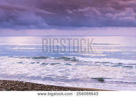 Calm Sea Waves Against A Dark And Stormy Sky
