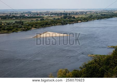 A Large River In Central Europe With A Sandy Island. A Sandstorm In The Middle Of A Large River.