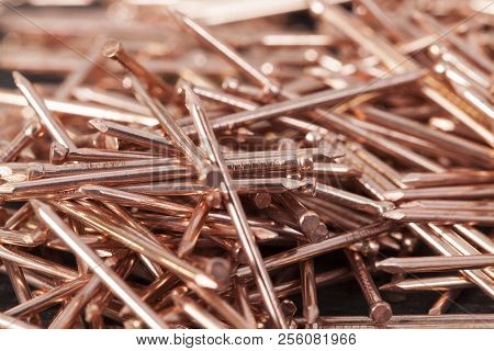 Copper Finish Nails Lying In A Pile, Close-up Of Metal Materials Used In Construction