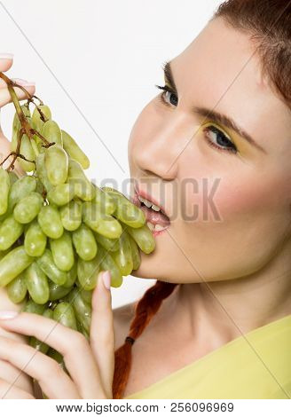 Beautiful Redhead Woman Licks Grapes. Concept Of Healthy Eating