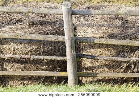 Stacks Of Old Last Year Straw Fenced Off By A Primitive Wooden Fence
